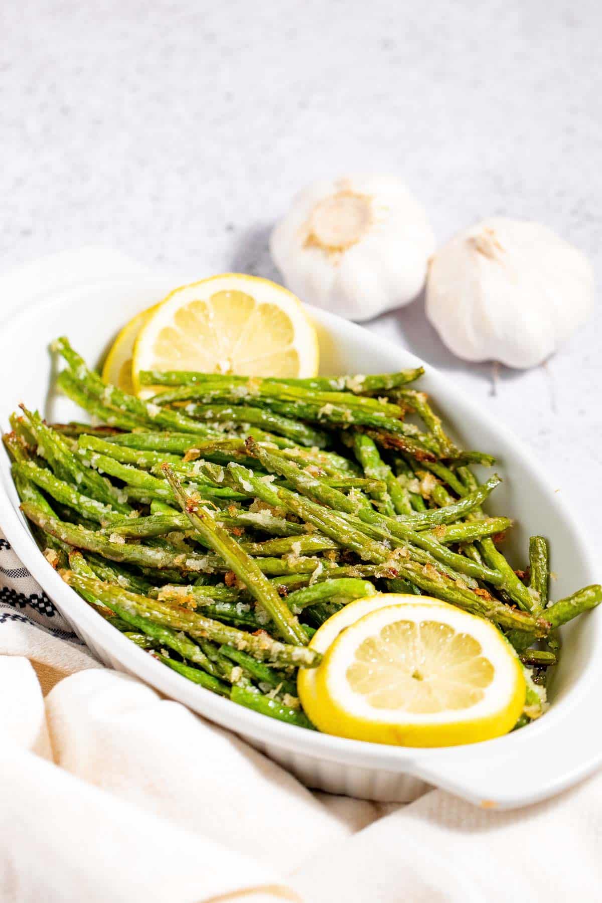 Roasted asparagus with lemon and garlic on a white plate.
