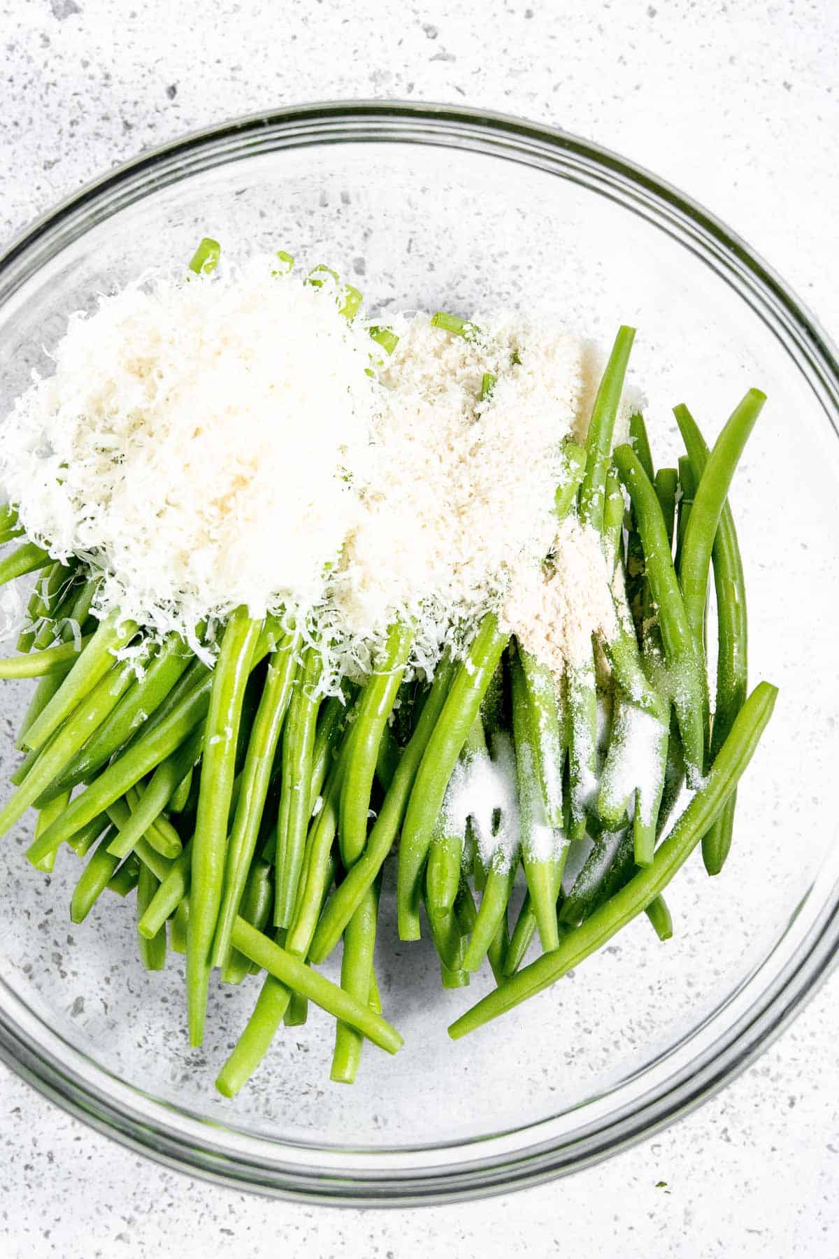 Green beans with parmesan cheese in a glass bowl.