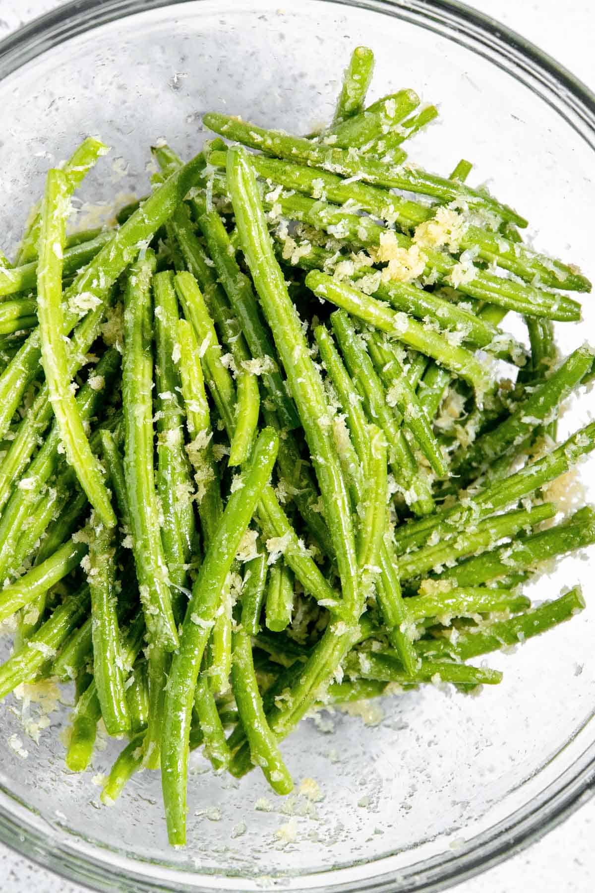 Green beans in a glass bowl with parmesan.