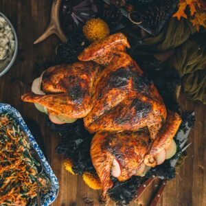 Roasted spatchcocked turkey on a wooden tabled with side dishes.