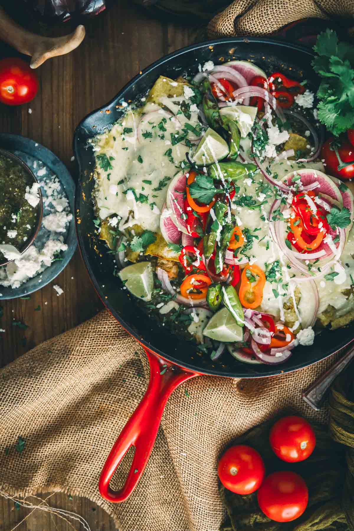 A skillet filled with turkey enchiladas and a red handle.