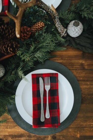 A table setting with a plaid napkin and silverware.