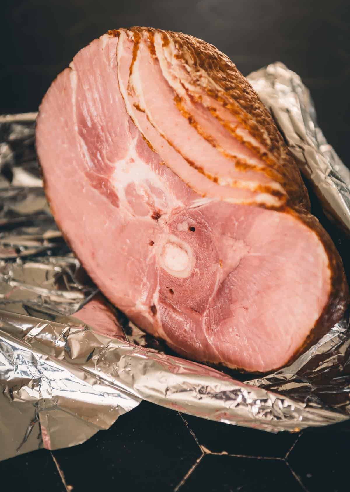 A spiral ham is sitting on a piece of foil.