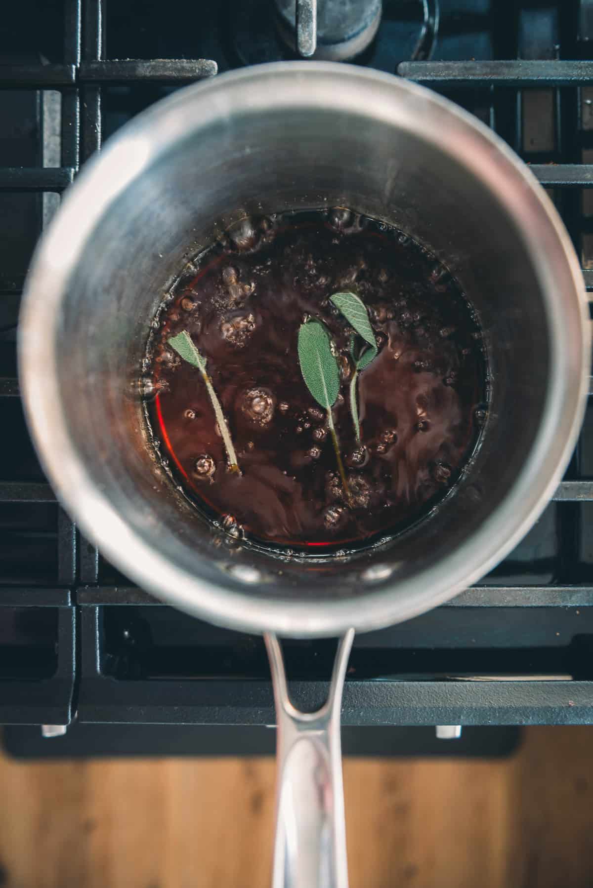 A pan on a stove with maple brown sugar glaze ingredients in it.