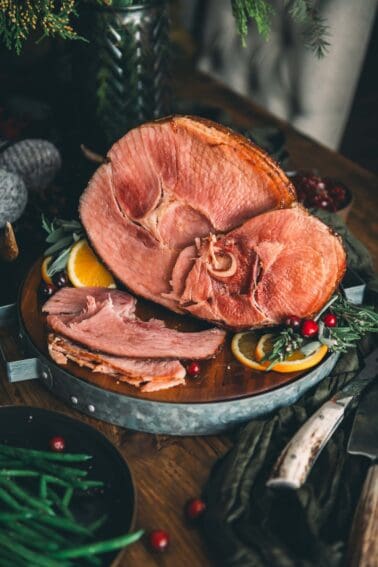 Spiral ham and green beans on a wooden table.