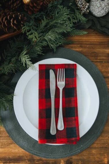 A red and black plaid napkin on a wooden table.