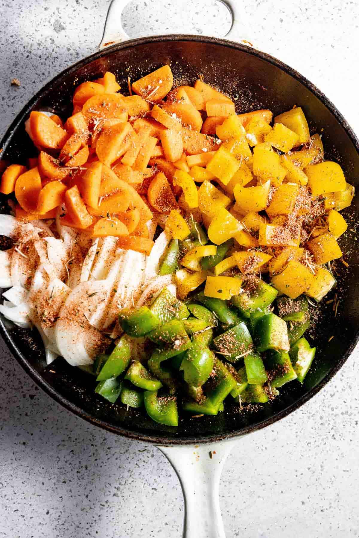 A frying pan filled with vegetables and spices.