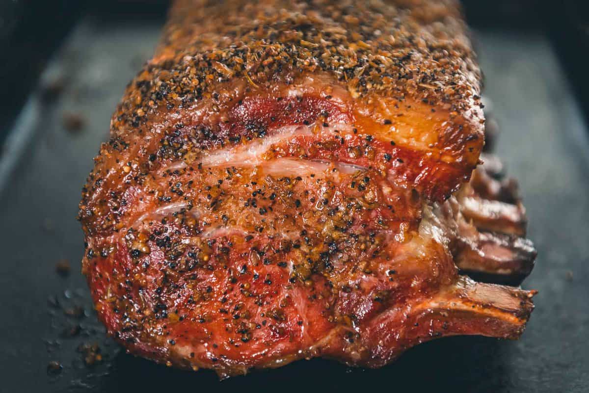 A pork roast sitting on a baking sheet to show the red color from the smoker.
