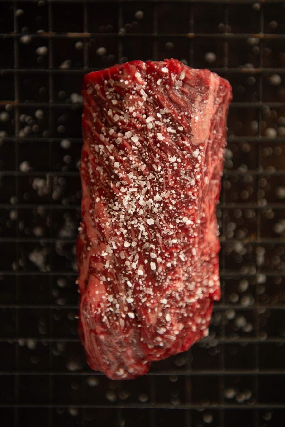 A piece of steak with salt on it.
