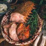 A plate of smoked pork with mashed potatoes and green beans on a wooden table.