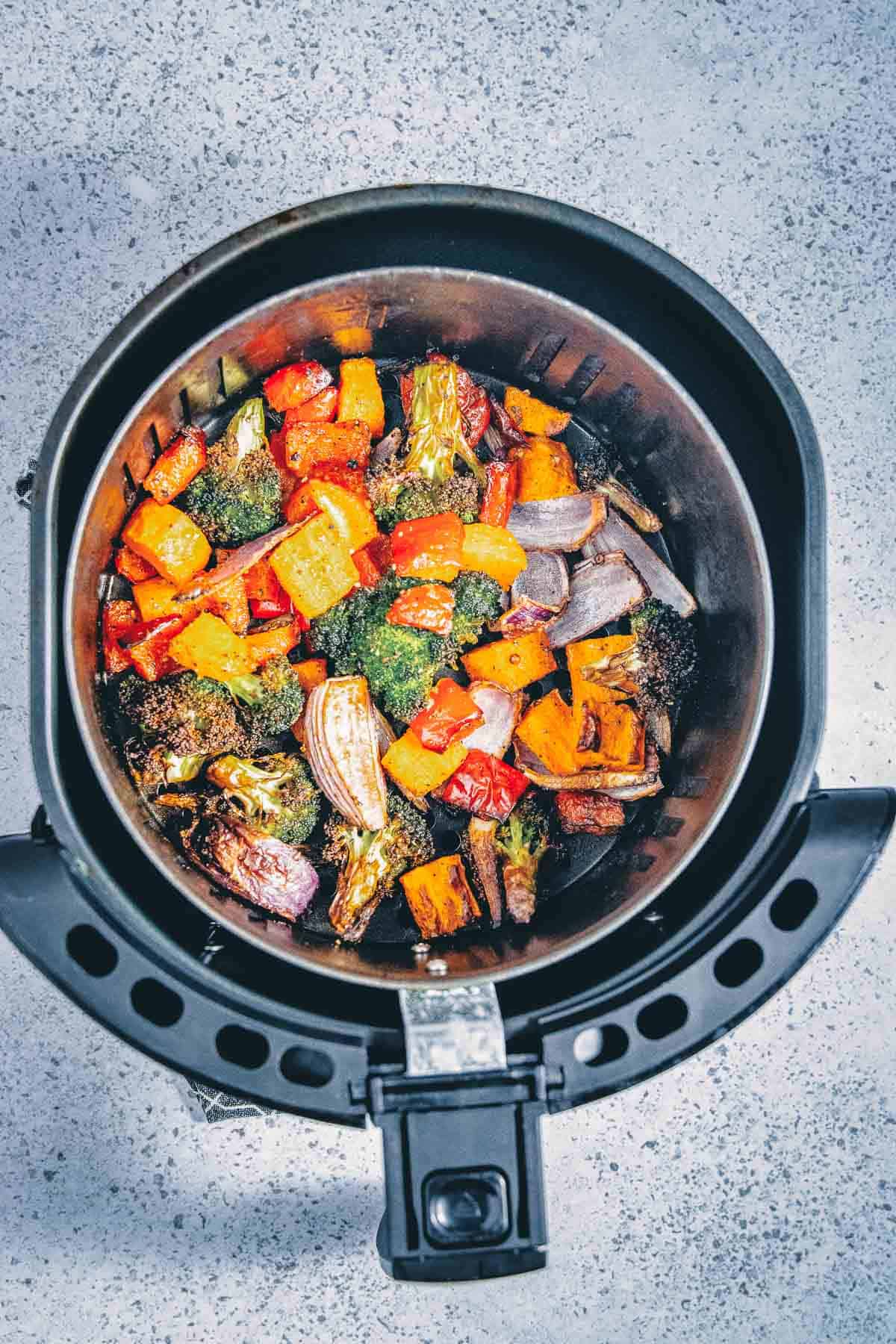 An air fryer filled with vegetables.