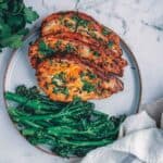 A plate with pork chops and baby broccoli on it.