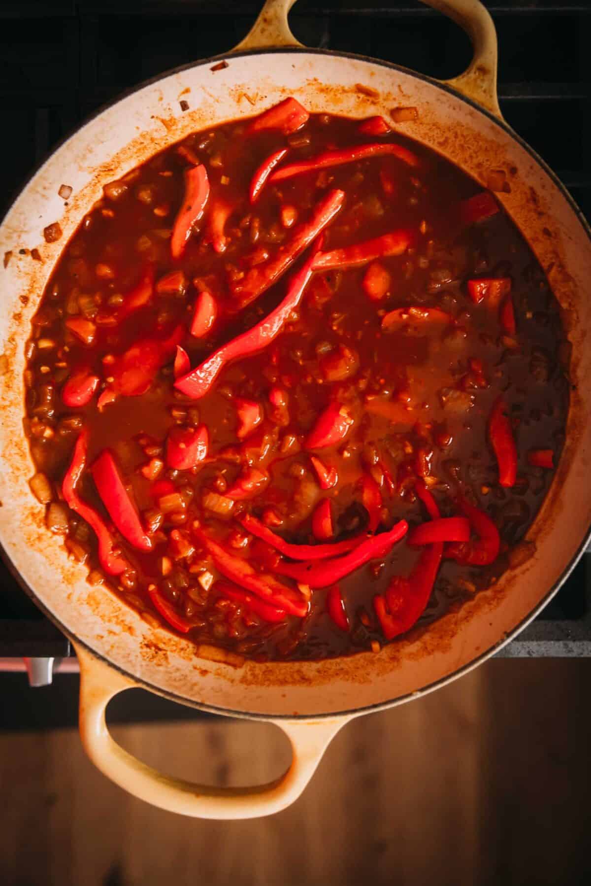 A pan with red peppers on top of a stove.