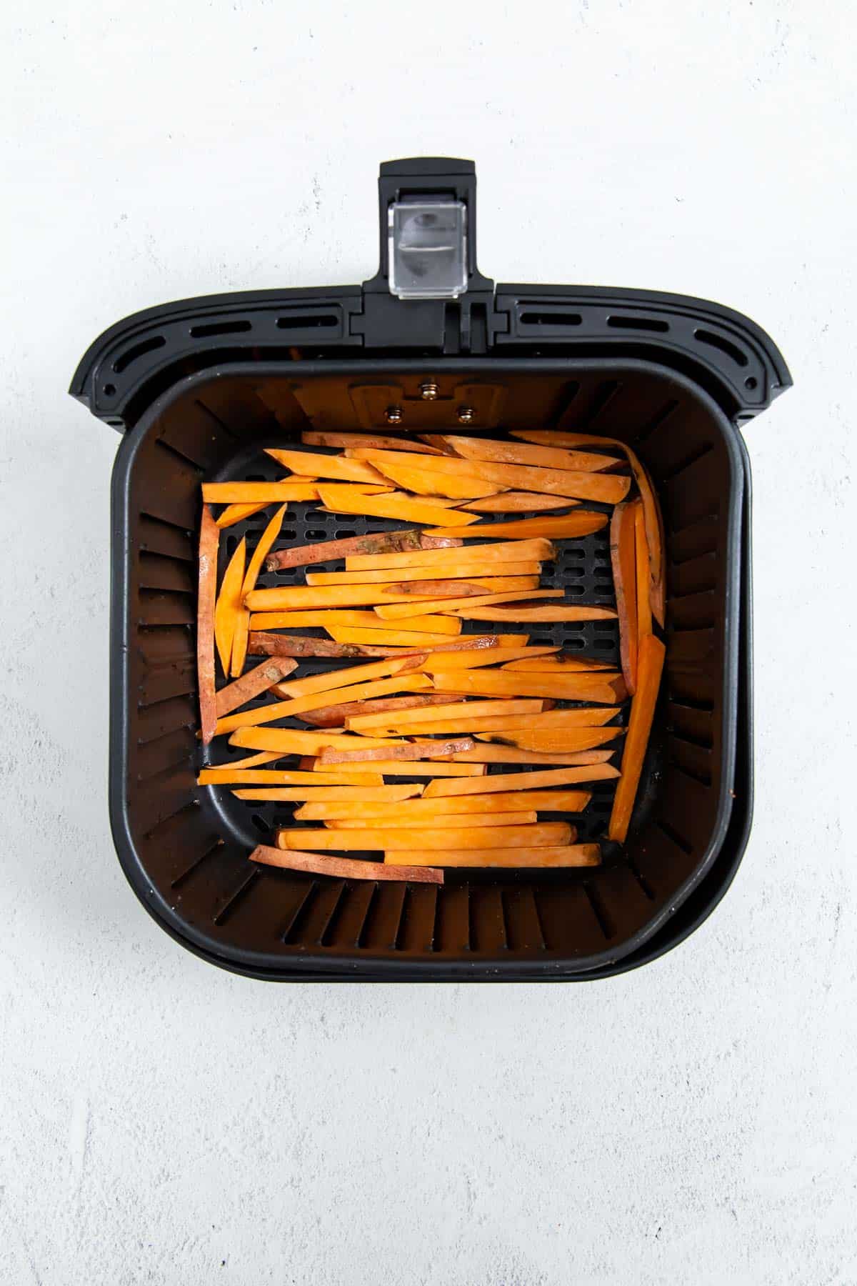 An air fryer filled with sweet potato fries.