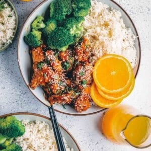 Air fryer orange chicken in a bowl with rice and steamed broccoli.