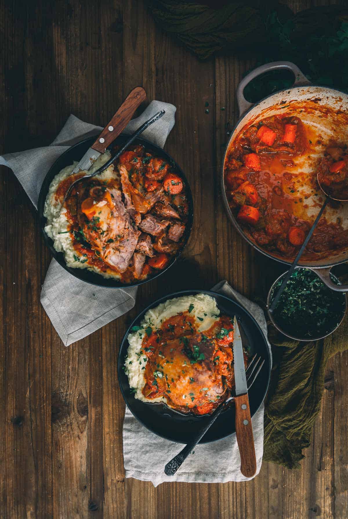 Three bowls of food on a wooden table.