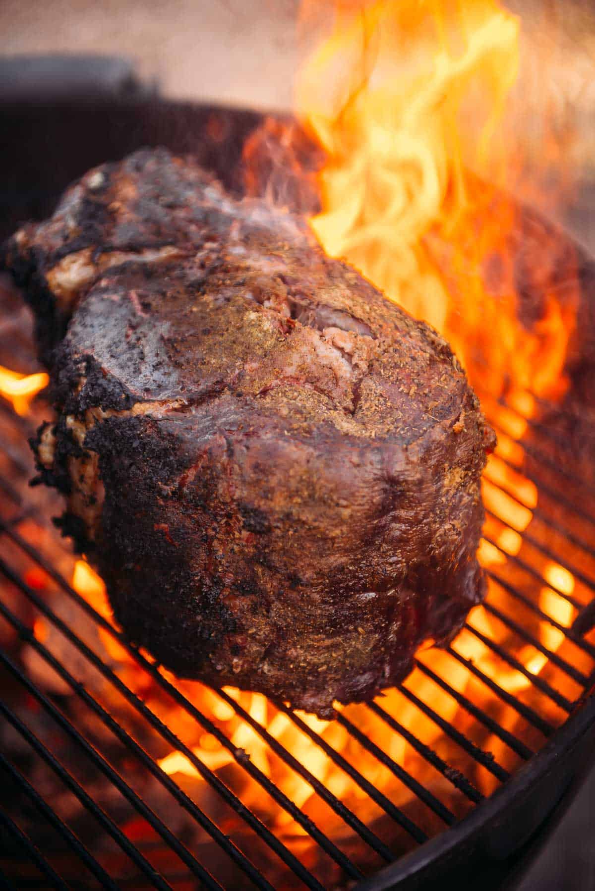 An example of a flare up; a prime rib on a grill with lots flames on it. 