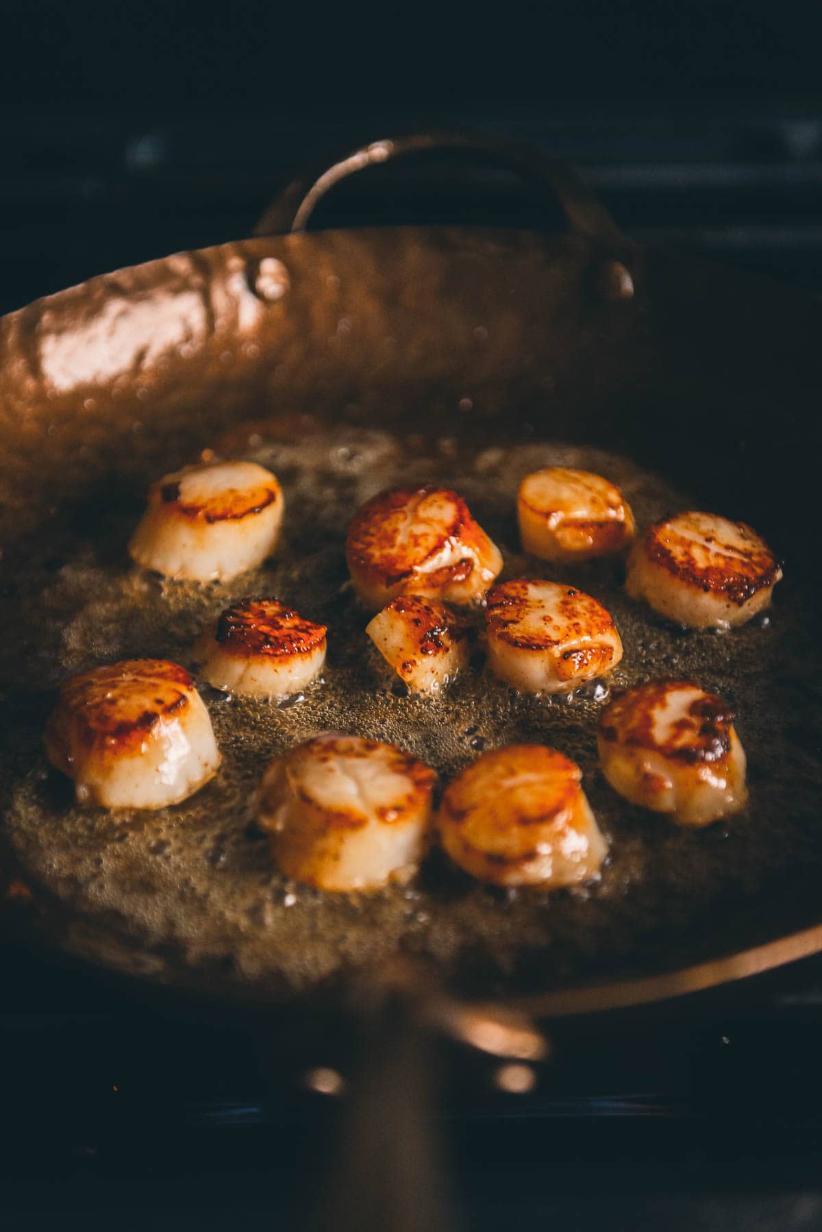 Scallops in a frying pan on the stove.