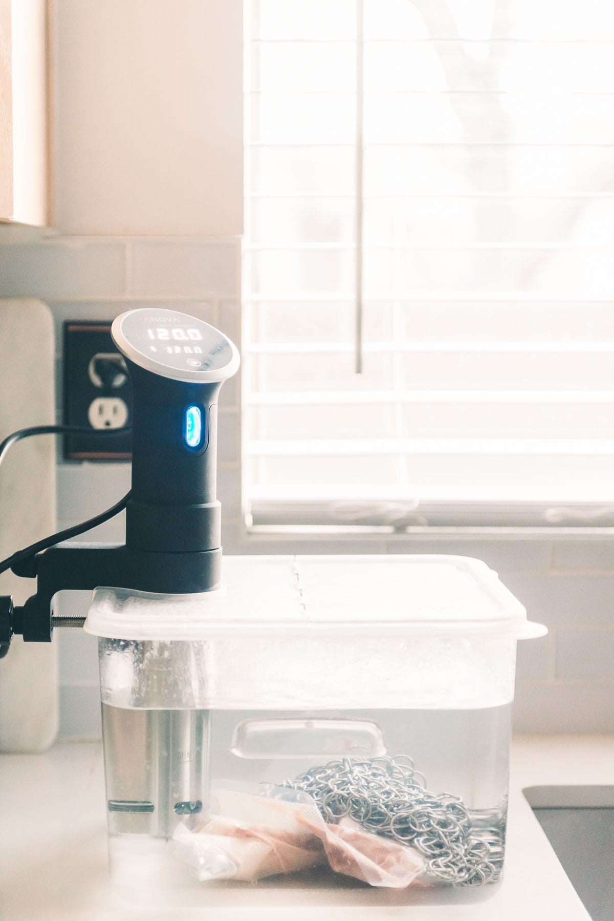 A sous vide machine and water bath on top of a counter.