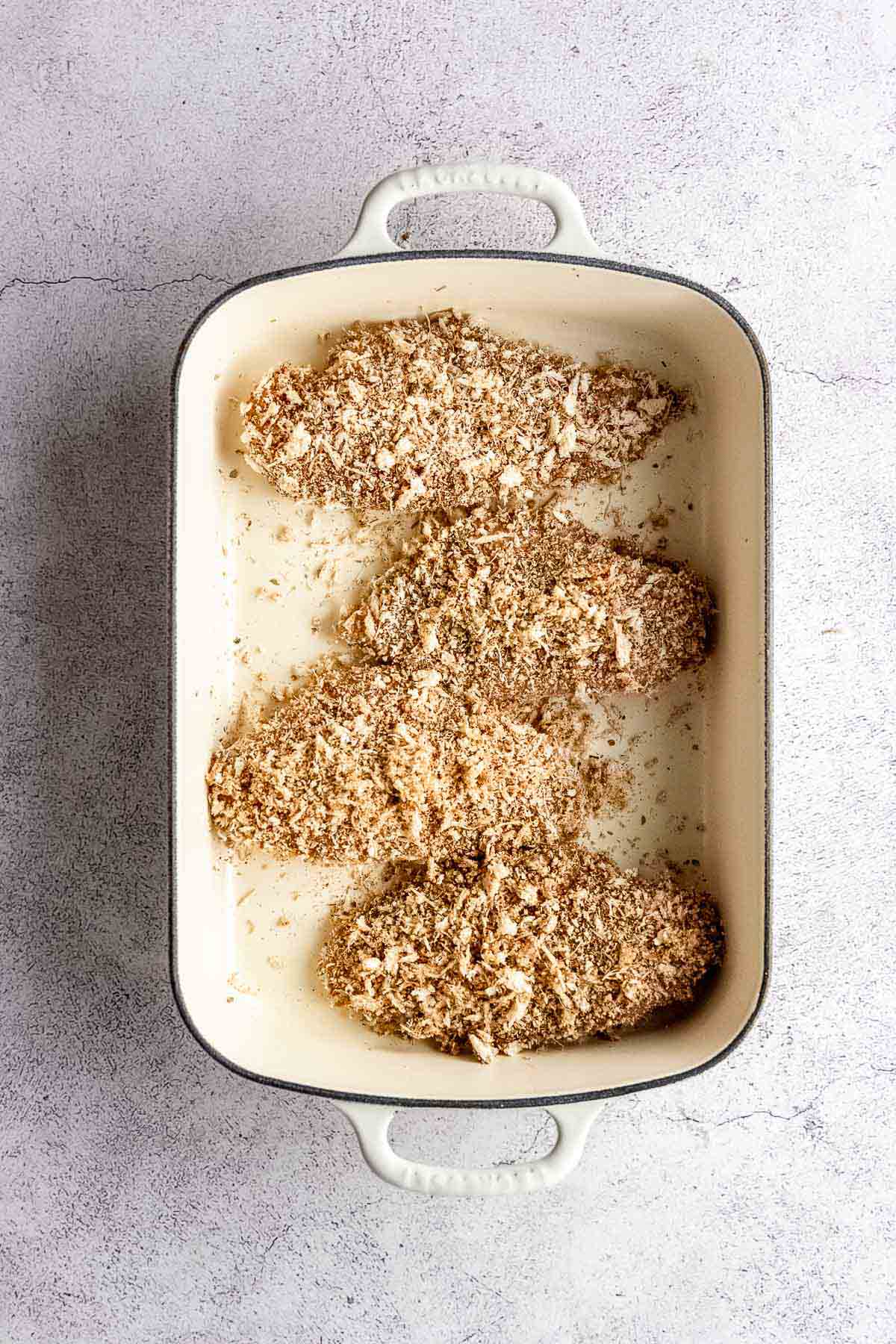 A baking dish filled with breaded chicken breasts.