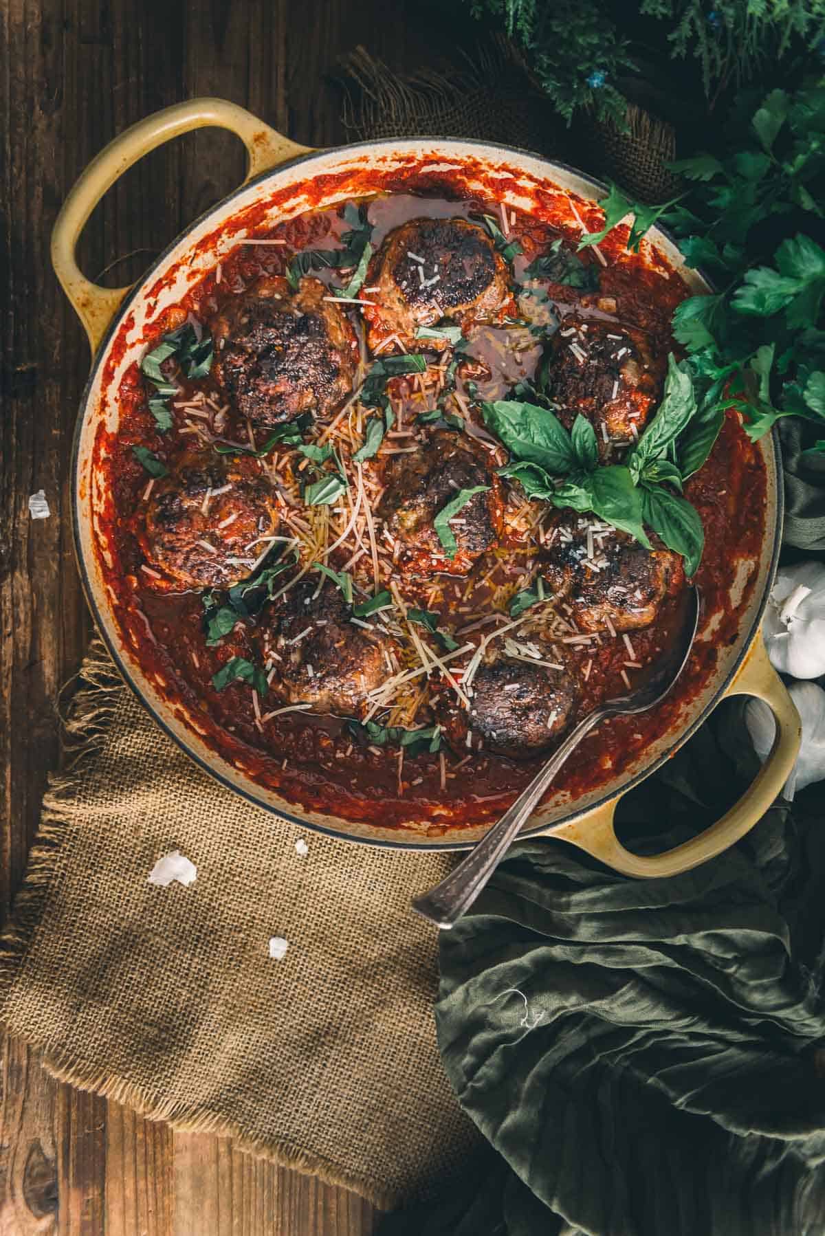 Meatballs in tomato sauce on a wooden table.