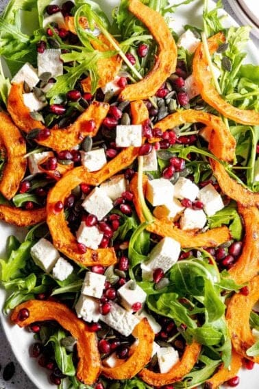 A plate of squash salad with feta and pomegranate.