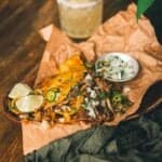 A plate of nachos on a wooden table.