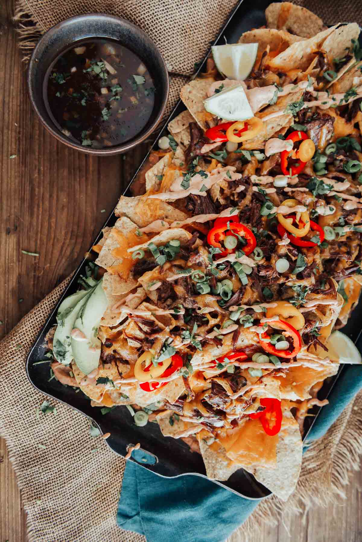 A tray of birria nachos on a wooden table.