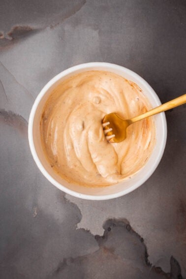 A bowl of chipotle aioli with a fork in it.