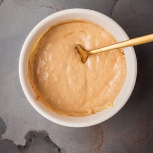 Horseradish aioli in a white bowl with a spoon.