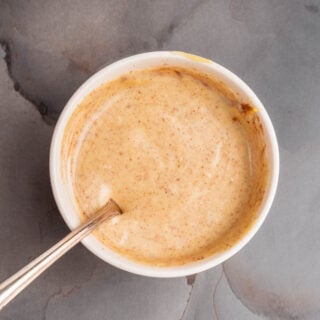 A bowl of maple aioli with a spoon in it.