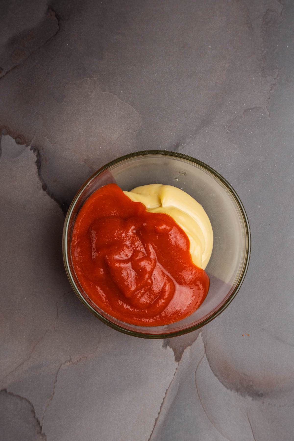 Sriracha and homemade aioli in a bowl on a gray background.