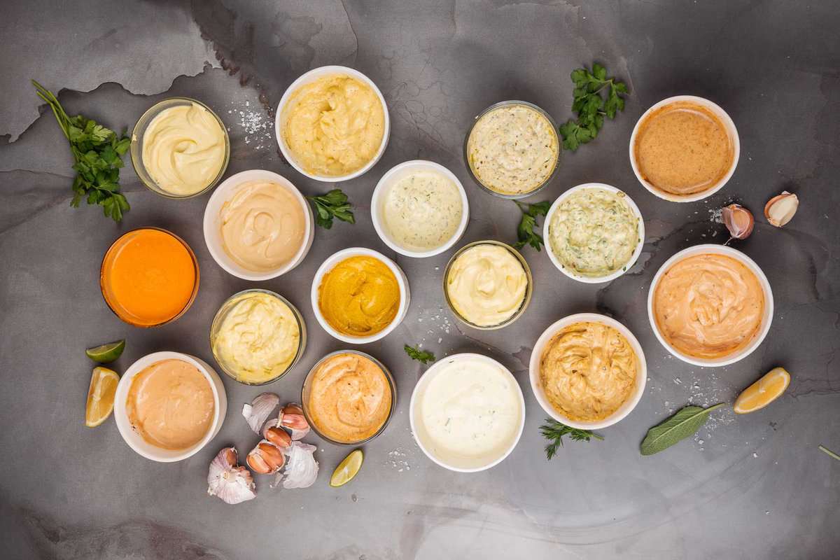 A variety of sauces in bowls on a gray background.