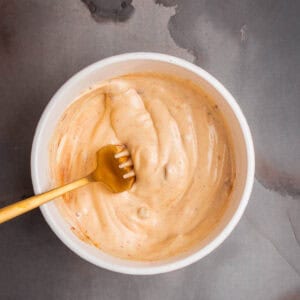 BBQ aioli recipe in a white bowl on a gray background.