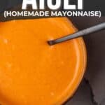 A bowl of sriracha aioli on a table with text overlay giving instructions on making it, titled "how to make sriracha aioli (homemade mayonnaise)" for a pinterest image.