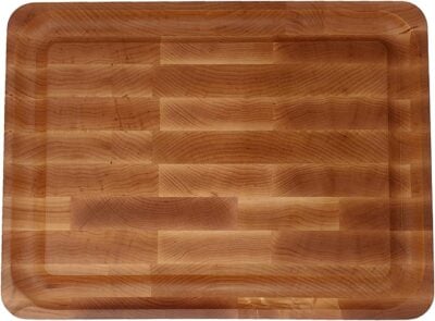 A rectangular wooden cutting board with a smooth finish, featuring a pattern of light and dark wood grain.