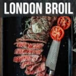 A pinterest image with grilled London broil topped with herb butter, sliced and served on a black tray with grilled tomato halves and a knife. Text above reads "How to make grilled London broil."