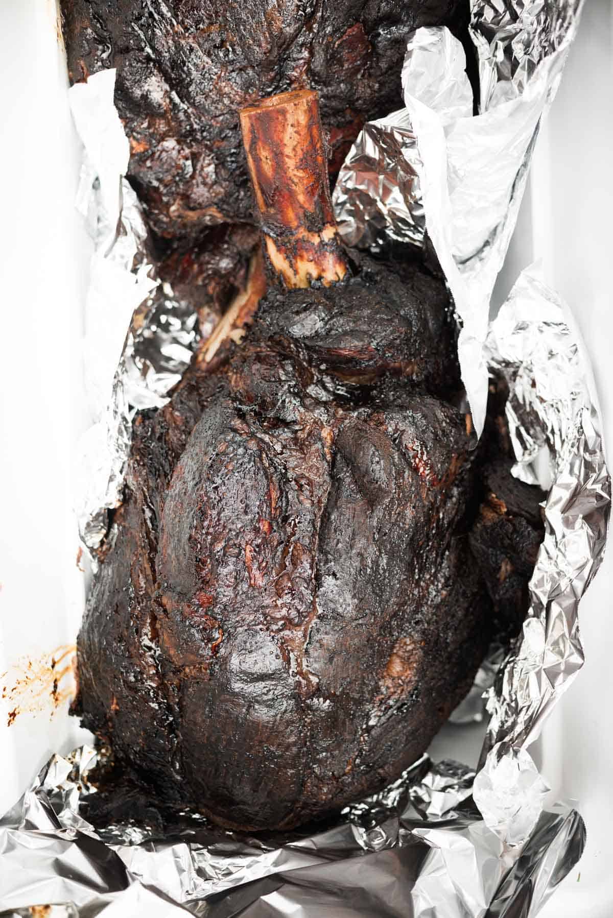 Smoked steamship round with good bark resting in foil.