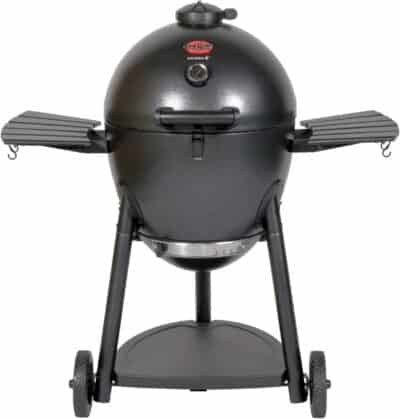 A black, egg-shaped charcoal grill with two side shelves, wheels at the base for mobility, and a temperature gauge on the lid—ideal for those exploring how to use a kamado grill.