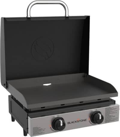 Image of a Blackstone outdoor griddle with two control knobs, a flat cooking surface, and an open hood. The griddle is black with stainless steel accents and is designed for grilling, making it an essential addition to any camp kitchen.