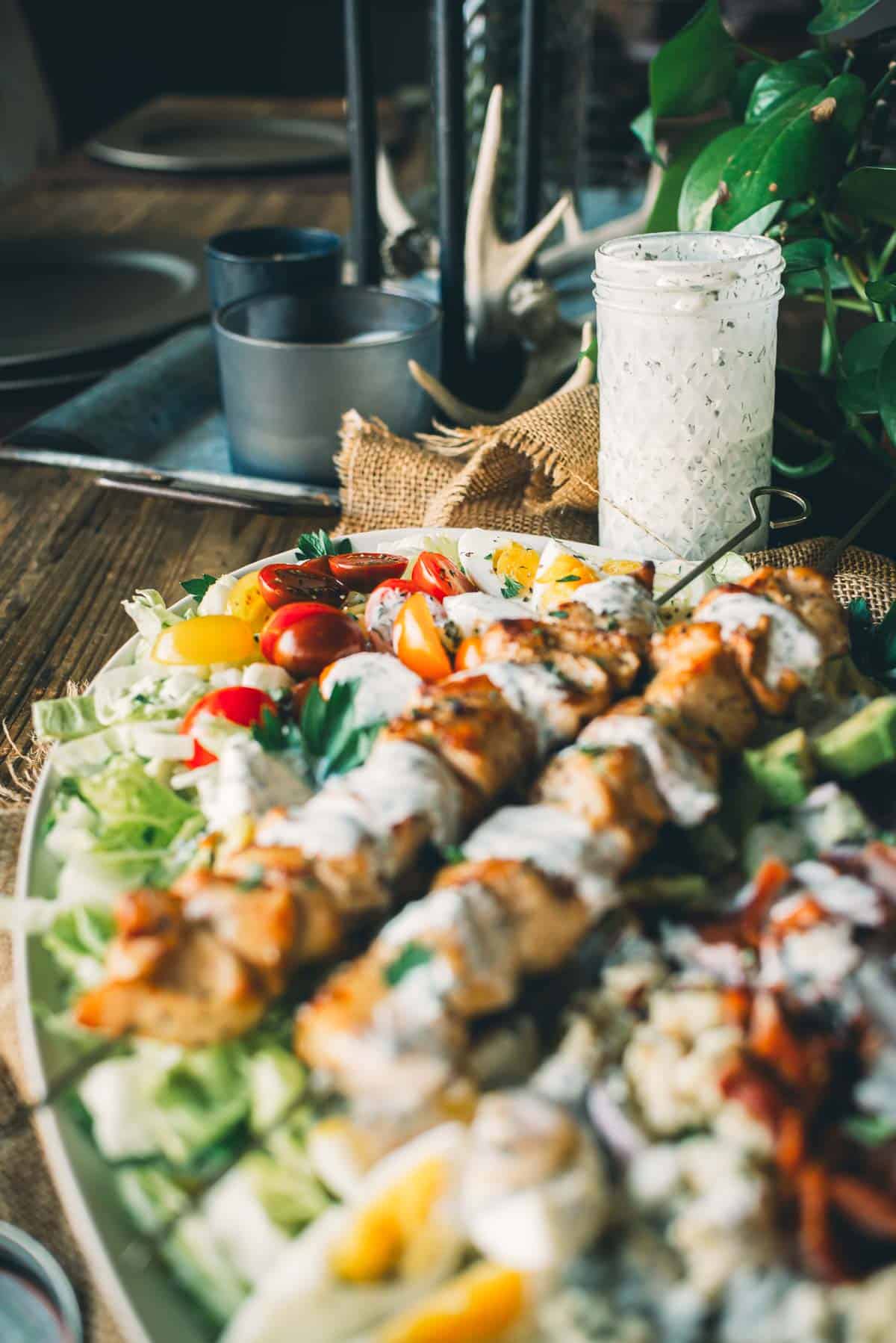 Bright colorful grilled cob salad with a jar of buttermilk ranch dressing in the background.