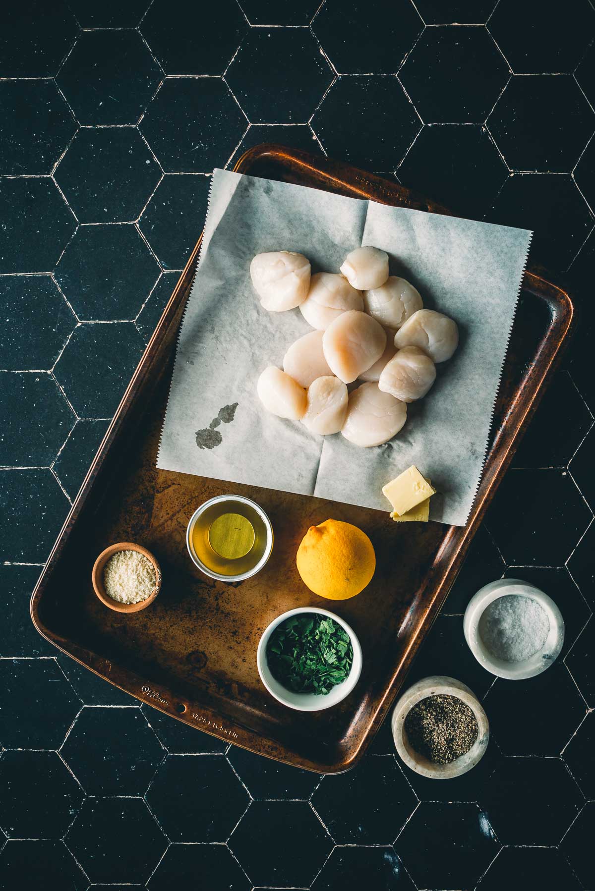 Ingredients for grilled scallops with raw large scallops, lemon, parmesan, parsley and more.