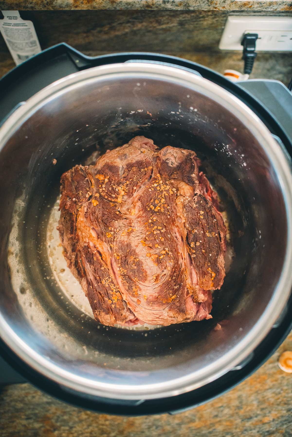 A chuck roast in an Instant Pot, ready for cooking.