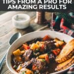 Pinterest image for beef stew tips: Bowl of beef stew with vegetables on a wooden table, accompanied by two slices of bread.