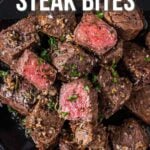 A plate of garlic butter steak bites garnished with herbs, showing juicy, cooked pieces of beef with a pink center. Text overlay gives recipe details and website information.