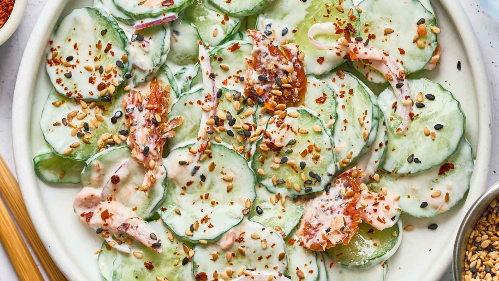 Philly roll cucumber salad with crab, cucumber ribbons, and creamy sauce drizzled over.