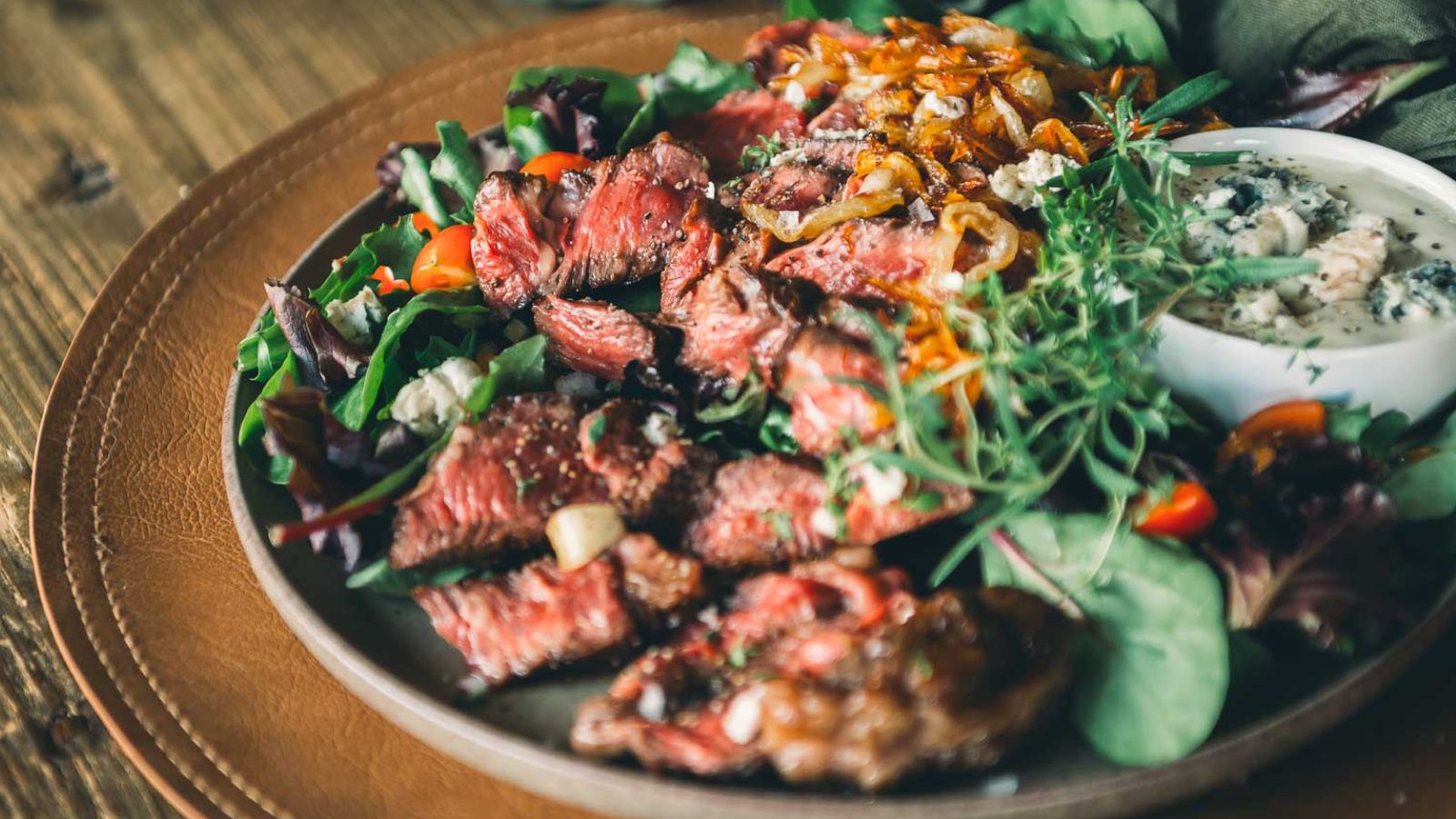 Pan-seared chuck eye steaks sliced to show juicy pink centers with browned crust.