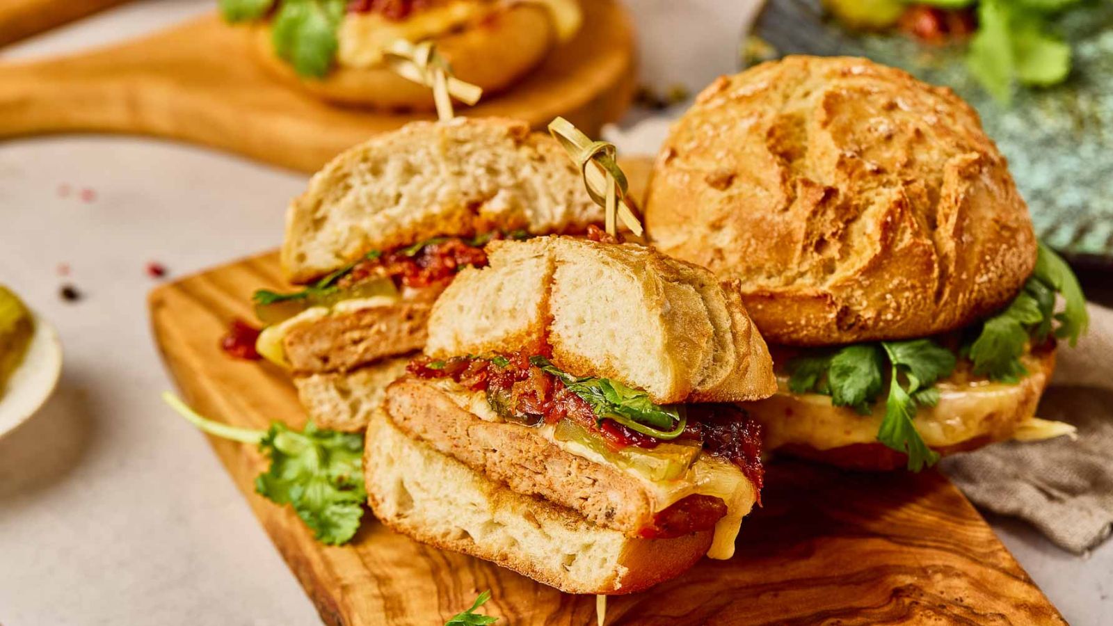 Gochujang Chicken Burgers cut in half and served on a wooden board.