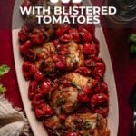 Oval platter with pan-seared cod fillets topped with blistered cherry tomatoes, set on a rustic table next to herbs, a fork, and a napkin. Text overlay provides recipe details.