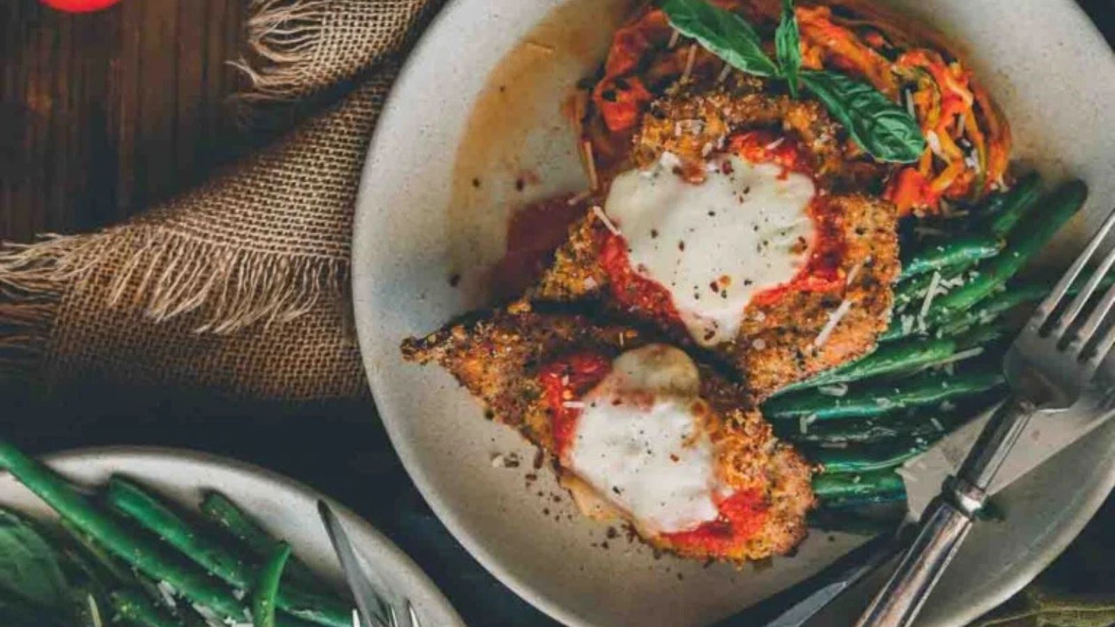 Air fryer veal Parmesan golden and topped with melted cheese and sauce.